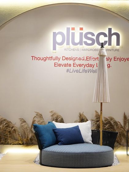 This image showcases the outdoor furniture collection within the Plüsch booth. The circular daybed and umbrella create a relaxed, resort-like vignette, demonstrating the versatility of the brand's offerings.