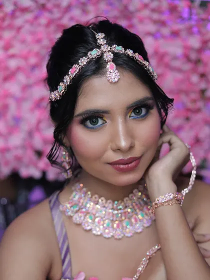 A close-up portrait of the model against a pink floral background, emphasizing the pretty and glamorous feel.