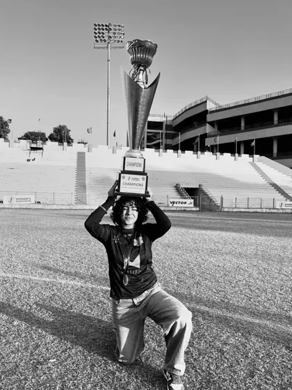 A captain lifts the trophy, a symbol of the team's hard work, perseverance, and shared passion.