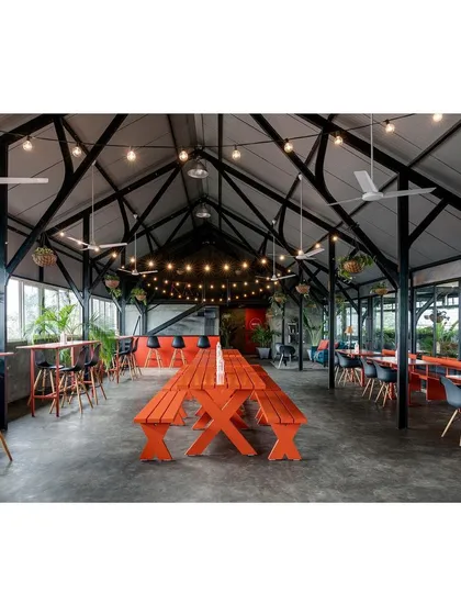This wide shot captures the full scale and flexible nature of the adaptive event space. The open floor plan, high ceiling, and connection to the outdoors make it a versatile canvas for a wide range of corporate and social events.