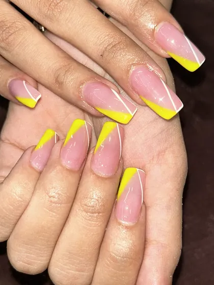 A bold and graphic French manicure. This design uses a bright yellow in an angular, asymmetric tip for a very modern and eye-catching look.