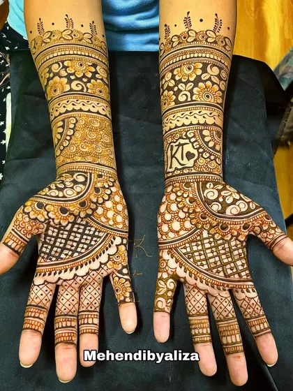 A gorgeous engagement henna design with initials, floral bands, and checkered patterns. This is a perfect example of a full, yet not overly dense, design.