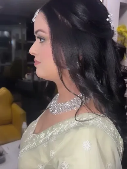 A side profile of our beautiful Sagan bride. The soft waves in her hair and the subtle, glowing makeup create a look of effortless elegance.