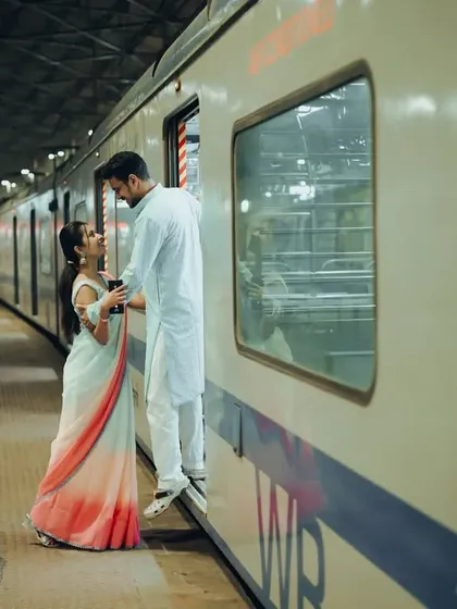 A playful moment from a pre-wedding shoot on a Mumbai local train. It's a creative concept that tells a story unique to the couple's life and city.
