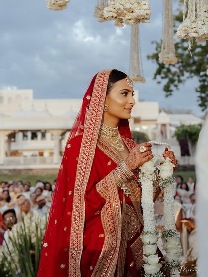 A beautiful shot during the varmala ceremony. The bride's side profile shows off her glowing skin and elegant hairstyle.