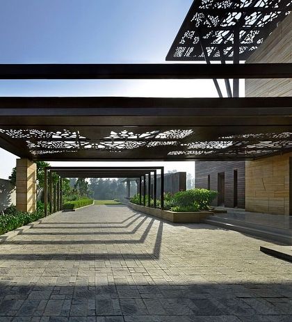 The entrance driveway to the Tree House is shaded by a laser-cut pergola, creating a beautiful play of dappled light and shadow on the ground. This transitional space sets a serene and artistic tone for the entire home.