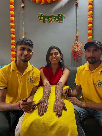 Two of my artists with a happy bride, showcasing her beautiful, intricate design.