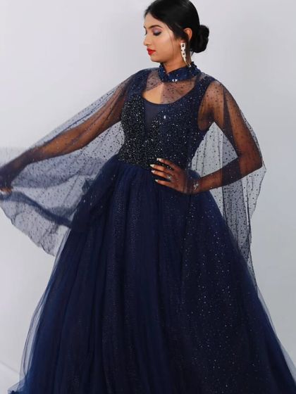The full silhouette of the navy blue ball gown, with the cape spread to showcase its dramatic effect.