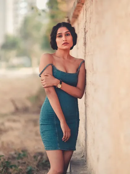 The same denim dress, this time without the blazer for a more casual, summery feel. The off-the-shoulder strap adds a touch of effortless style.