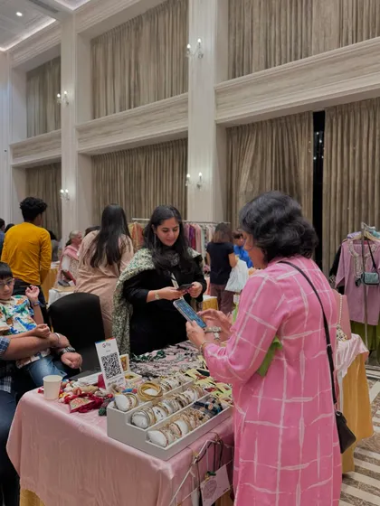 A customer making a digital payment at a jewellery stall. I ensure all logistics, including ease of payment, are smooth for both vendors and buyers.
