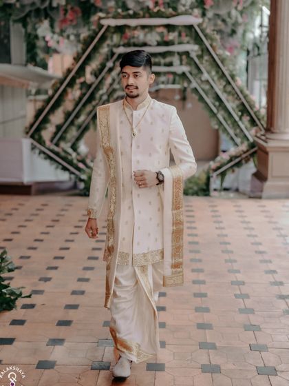 The groom making his entrance at the wedding hall, looking sharp in his traditional outfit.