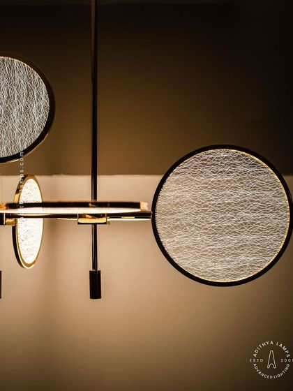 This artistic chandelier is composed of multiple circular discs with a unique woven texture. The layered arrangement and soft backlighting create a beautiful interplay of light and shadow, making it a captivating centerpiece.