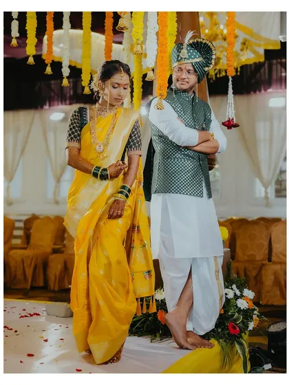 A stylish portrait of the bride and groom standing together under the mandap, showcasing their coordinated traditional attire.