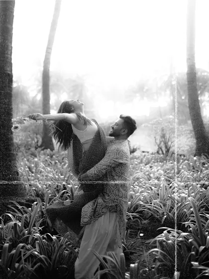 The same joyful lift, captured in a classic black and white film style. This artistic choice adds a timeless and dramatic feel to the moment.
