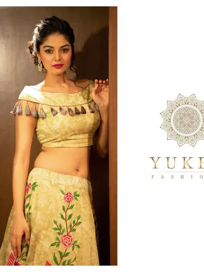 A contemporary take on the lehenga. This set features a boat-neck crop top with tassel details, paired with a matching skirt embroidered with delicate floral motifs.