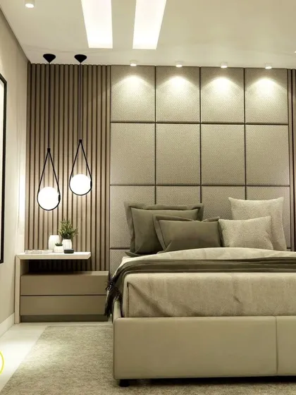 A stunning master bedroom with a large, upholstered headboard and dramatic pendant lights. The design exudes luxury and comfort.
