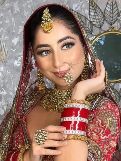 A beautiful shot of a bride in her maroon lehenga, holding her chooda. The makeup is soft yet defined, perfect for a traditional ceremony.