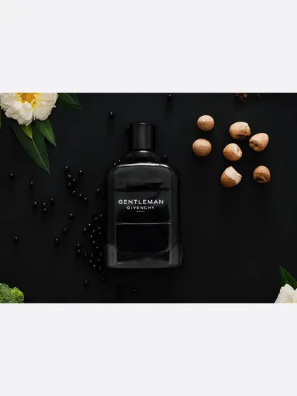A classic commercial product shot for a men's fragrance, styled with its core scent ingredients. This type of clean, descriptive photography is essential for e-commerce sites and print advertisements.