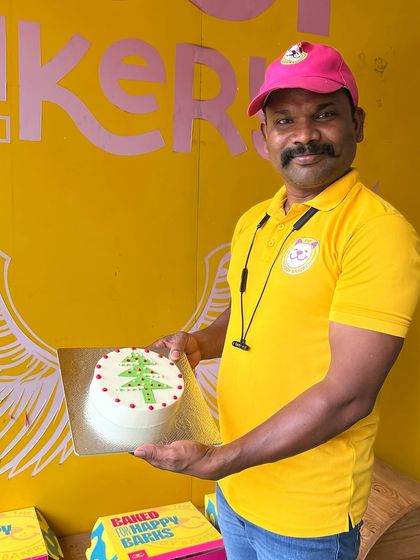 Our head chef proudly displays one of our seasonal Christmas cakes. Check our website for all our holiday specials!