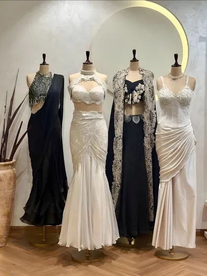 Black and white elegance. Our new collection features a range of stunning outfits in classic monochrome, including draped sarees, lace gowns, and embellished cape sets.