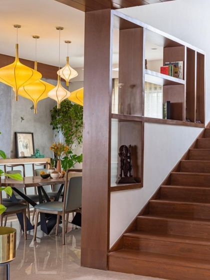 A view showing the transition from the staircase to the dining room, highlighting the custom partition with built-in shelving.