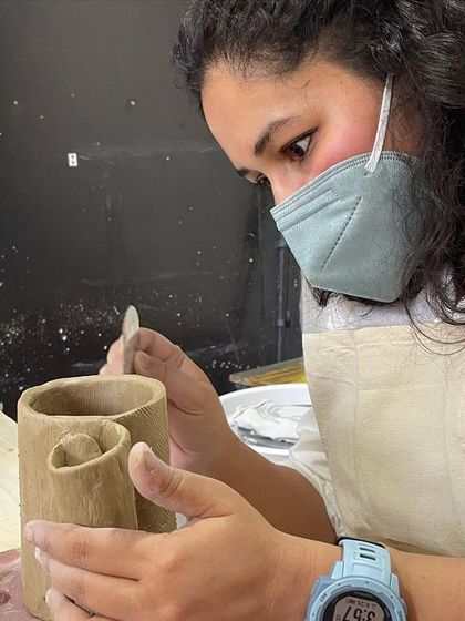 This student is creating a unique double-mouthed vase, showing the sculptural freedom of hand-building.