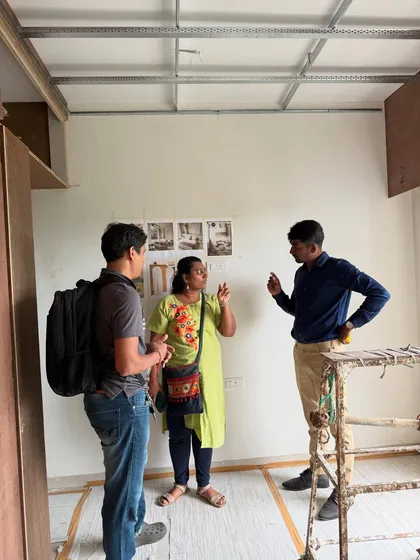 A discussion with clients on-site, with mood board images taped to the wall for reference during the construction phase.