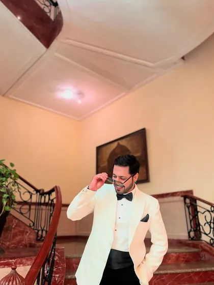 Looking sharp in a white tuxedo on a grand staircase. My look is always on point to match the grandeur of your event.