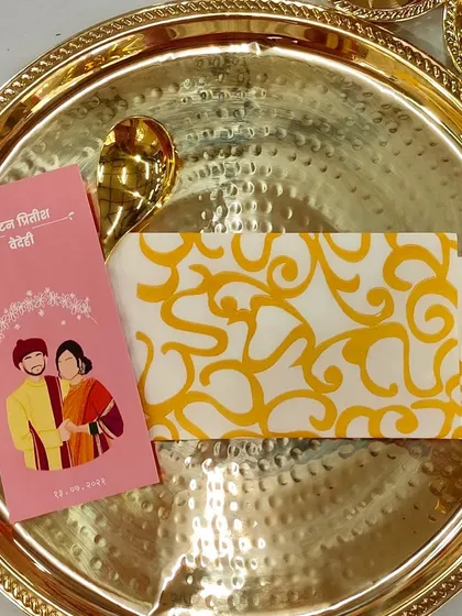A custom designed menu card with a cute caricature of the couple, placed on a traditional golden thali. This is a wonderful way to add a personal and playful touch to the wedding feast.