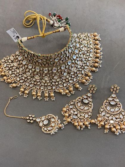 This heavy uncut Polki choker set comes with matching oversized earrings and a maang tikka. It’s a statement piece that guarantees a grand entrance.