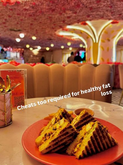 Even cheat meals are part of a healthy fat loss journey. This client is enjoying a grilled sandwich at a restaurant, proving that balance is key.