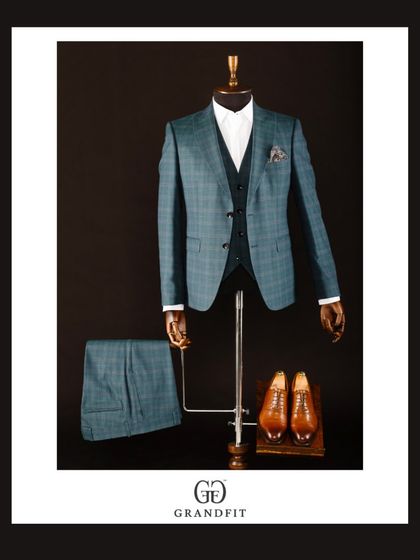 The full ensemble of the teal plaid suit, including matching trousers, showcases a cohesive and impactful statement.