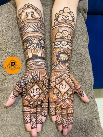 This engagement design features the couple's initials, 'J' and 'S', inside a diamond frame, and a ring motif on the other palm. It's a creative way to celebrate the occasion.