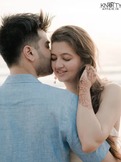 A tender moment from a pre-wedding shoot in Phuket, Thailand. The groom's gentle kiss on the bride's forehead and her happy, serene expression perfectly capture the romance of a beach sunset.
