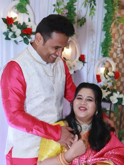 A sweet, candid moment between the new parents, sharing a happy look during the celebration.