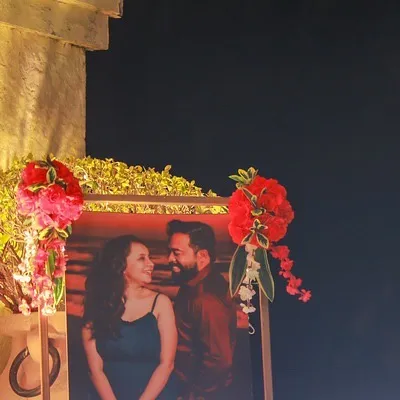 We love incorporating our clients' stories into the decor. This welcome stand features a beautiful photo of the couple, framed with red flowers, to greet guests as they arrive.