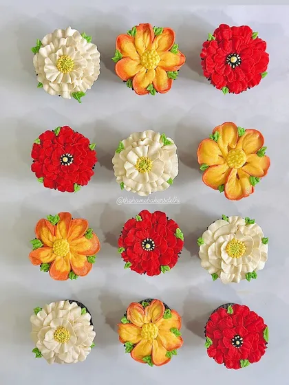 This is our buttercream artwork in full bloom. We hand-pipe every petal to create these vibrant, edible flowers. This box features a mix of our most requested floral designs, showing the variety of colors and styles we can craft for your custom cupcake order.