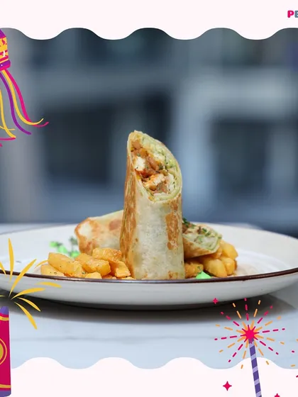 A freshly prepared shawarma wrap, grilled to perfection and served with a side of crispy fries. The wrap is generously filled, making it a wholesome and satisfying meal for any time of day.