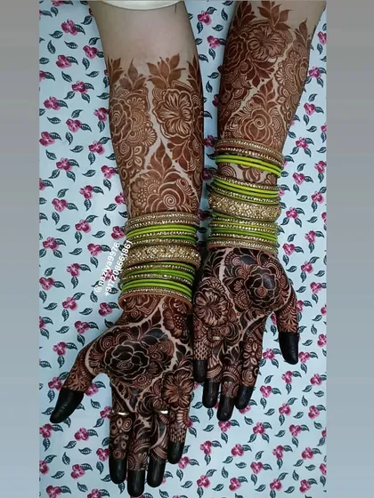 A full view of the bride's henna, complemented by her green bangles.