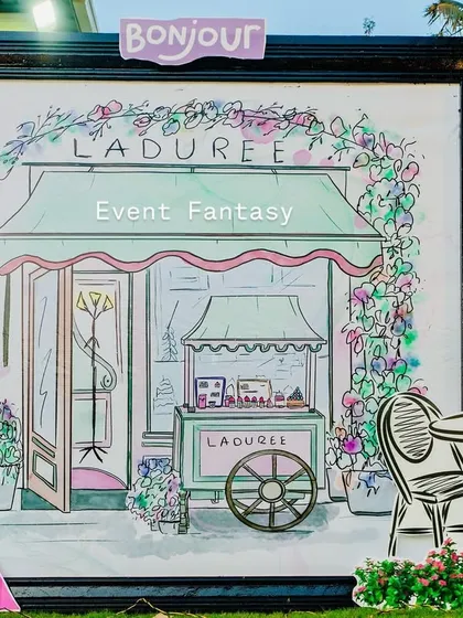 A charming prop featuring an illustration of a Ladurée patisserie, adding an authentic Parisian touch.