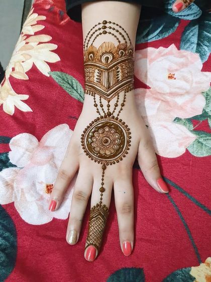 A classic back-of-hand design featuring a central mandala connected to a wrist cuff and a pattern on the finger. This is a timeless and elegant choice.