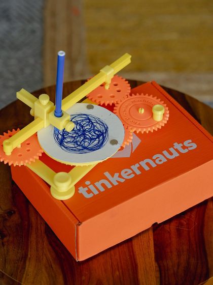 Our drawing machine kit, assembled and resting on its box, ready to create geometric art.