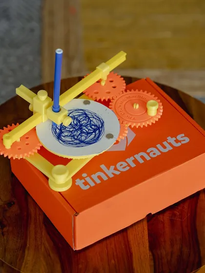 Our drawing machine kit, assembled and resting on its box, ready to create geometric art.