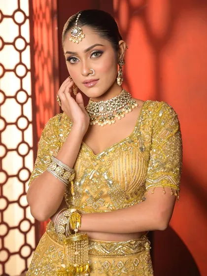 A confident and elegant pose. The golden tones in the makeup and outfit make the bride shine, perfect for her big day.