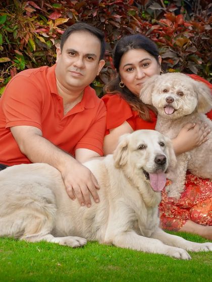 A wider shot of the family portrait, including the couple and their two furry companions.