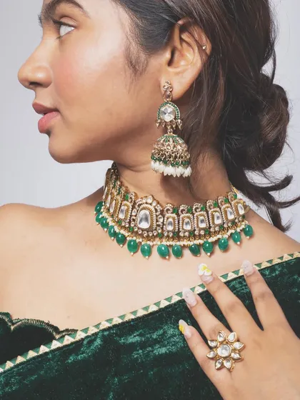A profile shot that elegantly displays the details of the jewelry set and the rich texture of the velvet saree, perfect for a catalogue or lookbook.