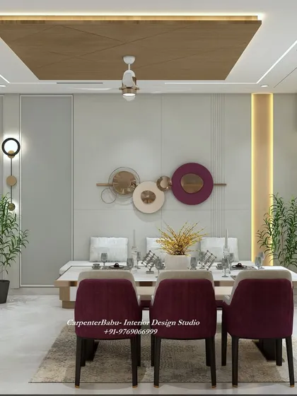 The dining table is set against a wall with circular metal art, adding a pop of color and a modern artistic touch. The bench seating is a great space-saving solution.