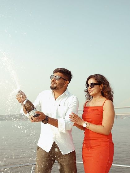 A celebratory moment on a private yacht in Goa, with champagne spray catching the sunlight. These are the fun, candid moments that make a luxury pre-wedding shoot so memorable.