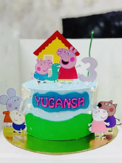 An adorable Peppa Pig themed cake, complete with Peppa's house and family, for a 3rd birthday.