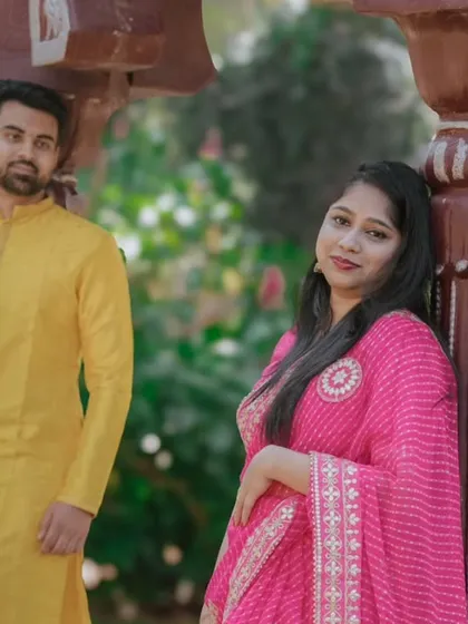 A simple yet elegant portrait of the couple in their traditional attire. The natural green background makes their colorful outfits stand out.